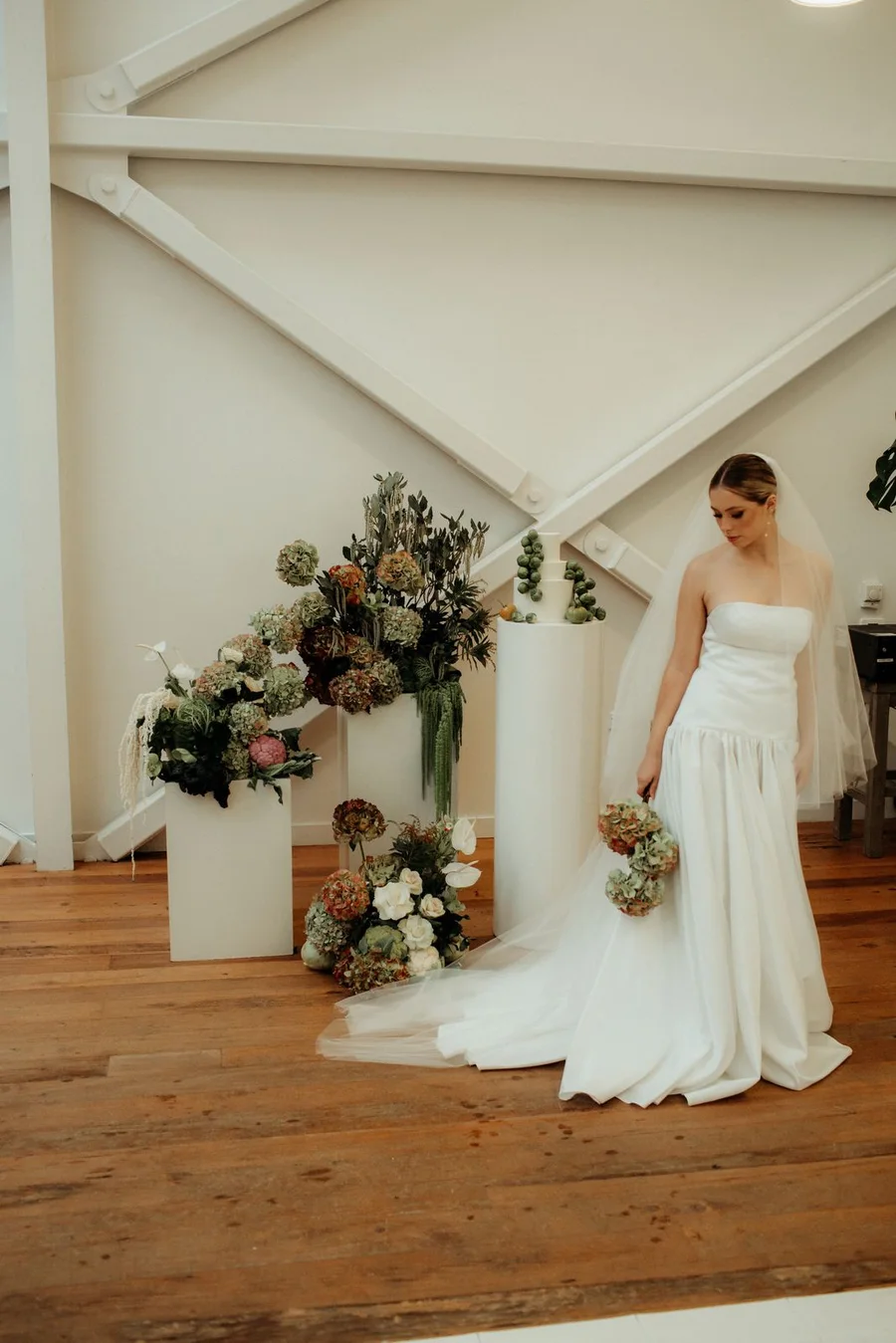 Bride in a Sarah Stoute gown at a Christchurch venue with seasonal florals